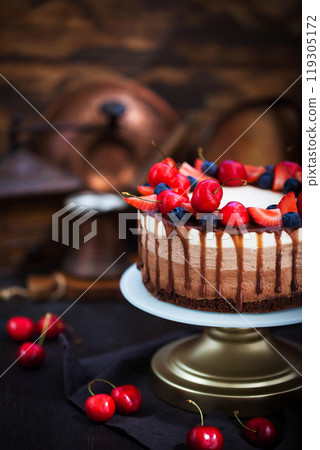 Delicious homemade Three chocolate mousse cake decorated with fresh berries Delicious homemade Three chocolate mousse cake decorated with fresh berries 119305172