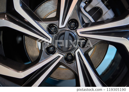 Detailed shot of a sleek black and silver alloy wheel on a motor vehicle Detailed shot of a sleek black and silver alloy wheel on a motor vehicle 119305190