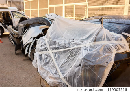 The automobile is covered in protective plastic for proper storage and safety measures The automobile is covered in protective plastic for proper storage and safety measures 119305216