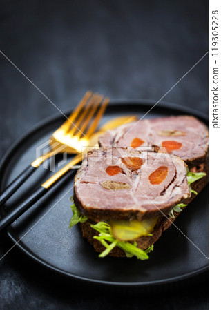 Gourmet sandwich with roasted pork (ham), pickled cucumber, lettuce, sauce, artisan bread Gourmet sandwich with roasted pork (ham), pickled cucumber, lettuce, sauce, artisan bread 119305228