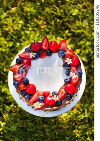 Delicious homemade Three chocolate mousse cake decorated with fresh berries 119305248