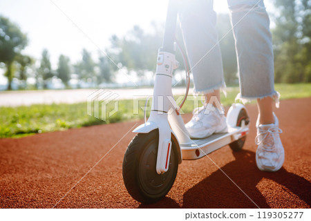 Legs of woman riding electric kick scooter on urban outdoor. Ecological transportation concept. 119305277