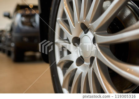Detailed shot of a sleek black and silver alloy wheel on a motor vehicle Detailed shot of a sleek black and silver alloy wheel on a motor vehicle 119305316