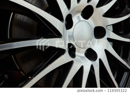 Detailed shot of a sleek black and silver alloy wheel on a motor vehicle Detailed shot of a sleek black and silver alloy wheel on a motor vehicle 119305322