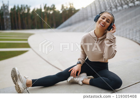 Sports woman in sportswear does exercises outdoors. . Sport, active lifestyle, healthy lifestyle concept. 119305408