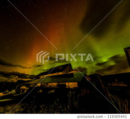 The Aurora Borealis, the northern lights, showing up above bungalow in County Donegal, Ireland 119305441