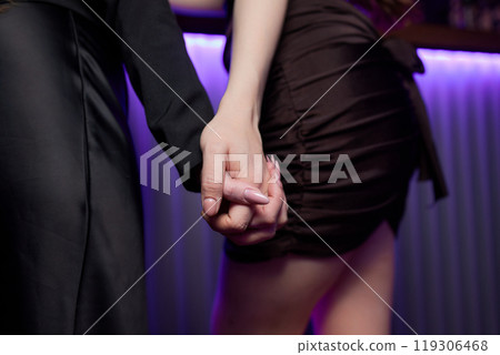 A Couple Enjoying Each Others Company While Holding Hands in a Lively Nightclub Setting A Couple Enjoying Each Others Company While Holding Hands in a Lively Nightclub Setting 119306468