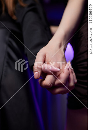A Couple Enjoying Each Others Company While Holding Hands in a Lively Nightclub Setting A Couple Enjoying Each Others Company While Holding Hands in a Lively Nightclub Setting 119306469