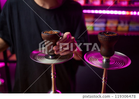 Person holding a hookah at a drinking establishment event Person holding a hookah at a drinking establishment event 119306478