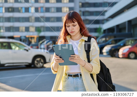 Young female college student using digital tablet outdoor Young female college student using digital tablet outdoor 119306727