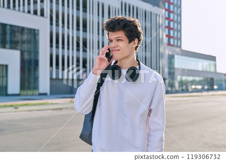 Young serious guy talking on mobile phone, modern city background, urban style 119306732