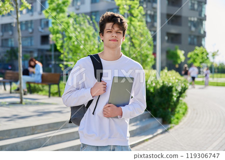 Outdoor portrait guy college student with backpack, laptop in hands Outdoor portrait guy college student with backpack, laptop in hands 119306747
