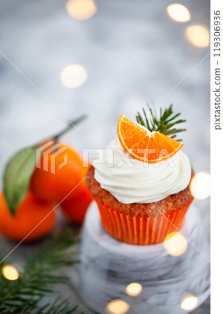 Homemade delicious tangerine and carrot cupcakes, decorated with creamcheese and fresh citrus fruits 119306936