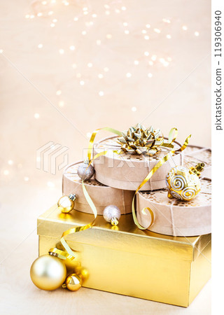 Christmas or New year round kraft gift boxes, gold holiday balls on a bokeh background of twinkling party lights of garland Christmas or New year round kraft gift boxes, gold holiday balls on a bokeh background of twinkling party lights of garland 119306940