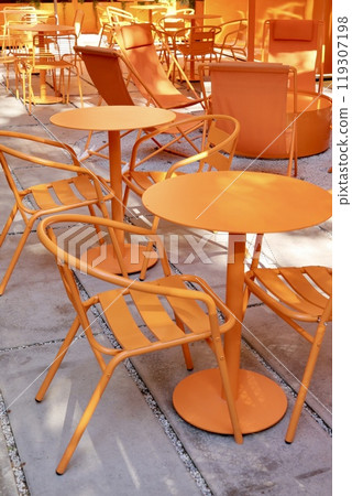 Coffee shop restaurant, orange furniture tables and chairs for guests. cozy street with cafe tables Coffee shop restaurant, orange furniture tables and chairs for guests. cozy street with cafe tables 119307198
