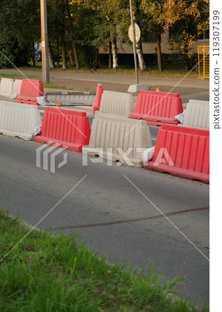 Red, white plastic safety barriers along roads. Ensuring road safety with visible barriers Red, white plastic safety barriers along roads. Ensuring road safety with visible barriers 119307199