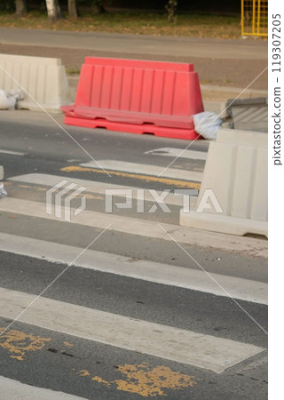 Red, white plastic safety barriers along roads. Ensuring road safety with visible barriers Red, white plastic safety barriers along roads. Ensuring road safety with visible barriers 119307205