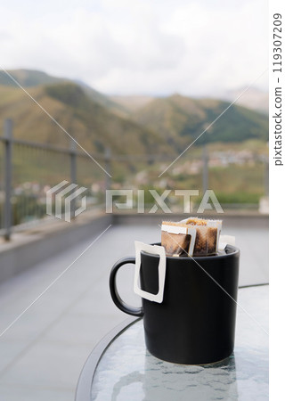 Drip coffee bag with ground coffee in cup. Making freshly coffee in mug. Drip coffee bag with ground coffee in cup. Making freshly coffee in mug. 119307209