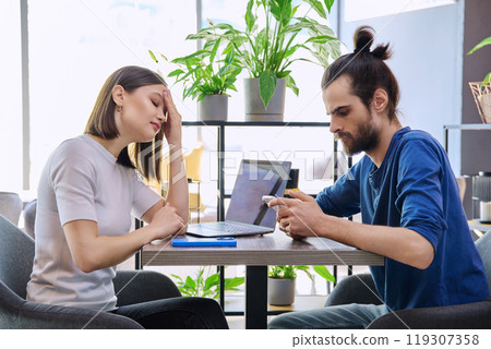 Serious sad upset young couple sitting together in cafeteria 119307358