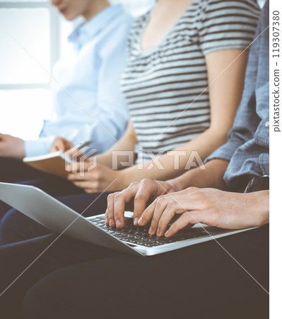 Group of casual dressed business people working at meeting or conference, close-up of hands. Businessman using laptop computer. Teamwork or coaching concept Group of casual dressed business people working at meeting or conference, close-up of hands. Businessman using laptop computer. Teamwork or coaching concept 119307380