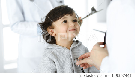 Woman-doctor examining a child patient by stethoscope. Cute arab toddler at physician appointment. Medicine concept Woman-doctor examining a child patient by stethoscope. Cute arab toddler at physician appointment. Medicine concept 119307441