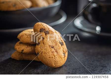 Biscotti frollini con gocce di cioccolato. Chocolate cookies on black table. 119307458