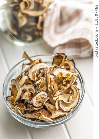 Dried porcini mushrooms. Sliced boletus in bowl on white table. Dried porcini mushrooms. Sliced boletus in bowl on white table. 119307468