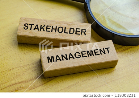 Stakeholder Management text on wooden blocks with magnifying glass background. Focus on stakeholder management concept 119308231