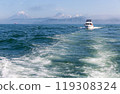 Boat Sailing in a Sea with Volcanoes On the Background 119308324