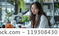 Female Asian Scientist Using Microscope In Research Lab 119308430