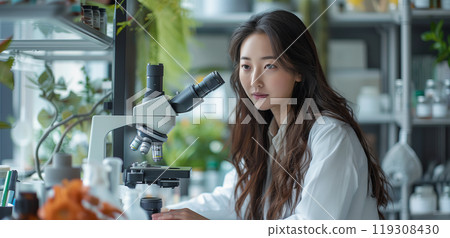 Female Asian Scientist Using Microscope In Research Lab 119308430