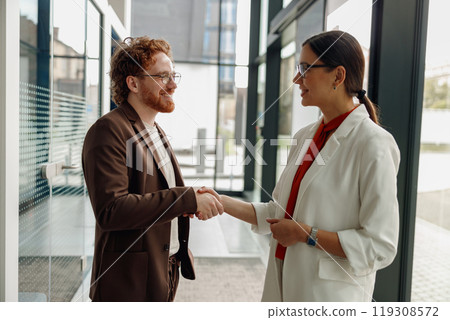 A handshake in an office symbolizes mutual agreement and highlights the importance of collaboration 119308572