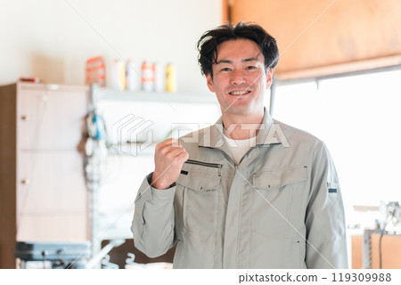 A middle-aged man wearing construction or civil engineering work clothes in a warehouse, workshop, or factory 119309988