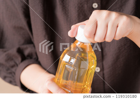 女人的手打開塑膠茶瓶的蓋子 119310180