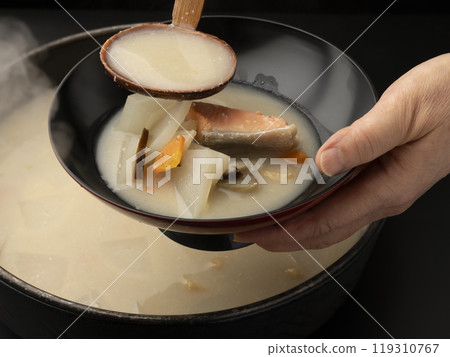 將酒糟湯舀入碗中。 119310767