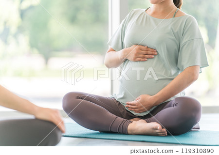 Young pregnant woman doing maternity yoga in yoga class Young pregnant woman doing maternity yoga in yoga class 119310890