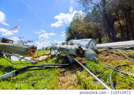In aftermath of hurricane, damaged power lines are lying on ground with broken cables In aftermath of hurricane, damaged power lines are lying on ground with broken cables 119310972