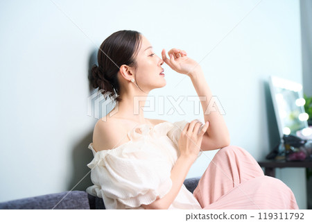 一個女人坐在沙發上 119311792