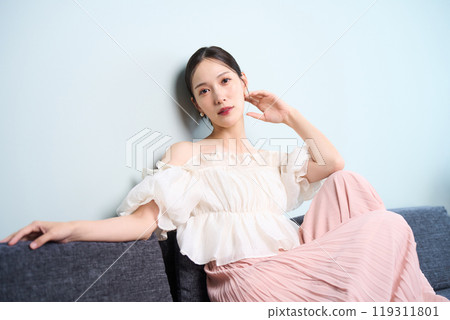 A woman sitting on a sofa 119311801