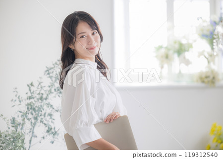 一位微笑的年輕女子用電腦看著鏡頭 — 工作變動與招募的圖片 119312540