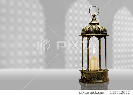 Ornamental arabic lantern with burning candle on the table. Muslim holiday decoration Ornamental arabic lantern with burning candle on the table. Muslim holiday decoration 119312632