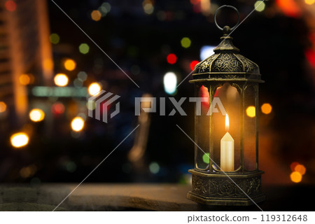 Ornamental arabic lantern with burning candle on the table. Muslim holiday decoration 119312648