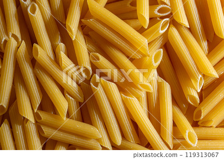Uncooked Penne Rigate Pasta Background Uncooked Penne Rigate Pasta Background 119313067