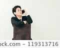 20 多歲的日本男子穿著西裝坐在椅子上打電話 119313716