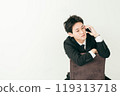 20 多歲的日本男子穿著西裝坐在椅子上打電話 119313718