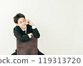20 多歲的日本男子穿著西裝坐在椅子上打電話 119313720