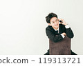 20 多歲的日本男子穿著西裝坐在椅子上打電話 119313721
