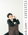 20 多歲的日本男子穿著西裝坐在椅子上打電話 119313723