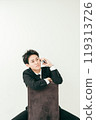 20 多歲的日本男子穿著西裝坐在椅子上打電話 119313726