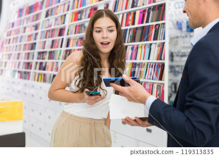 Salesperson helping female shopper to choose a new smartphone at an store 119313835